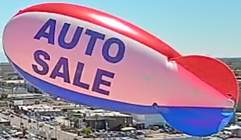 Custom red white and blue Auto Sale polyurethane advertising blimps flying over a car dealership lot