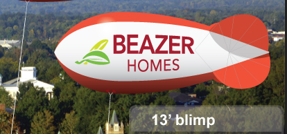13 ft Beazer Homes custom advertising blimp flying over trees and buildings